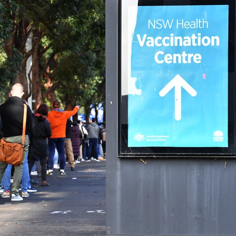 People are seen queued to receive their vaccination at the NSW Vaccine Centre at Homebush Olympic Park in Sydney.