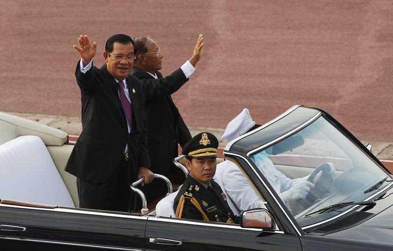 Prime Minister Hun Sen waves to government civil servants with his National Assembly President Heng Sermin, during the country's 40th anniversary celebrations. 