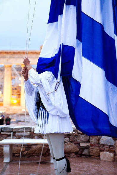 Greek Presidential Guard member covered by Greek flag