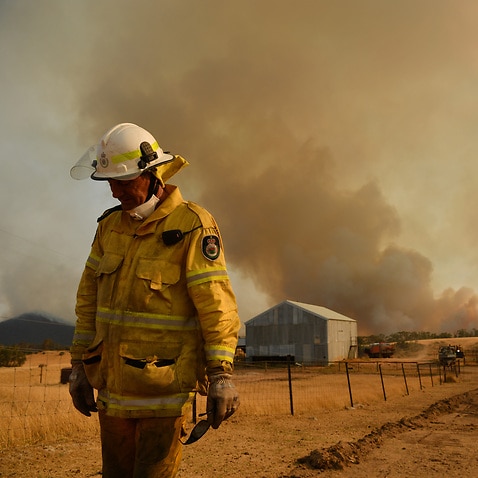 A Rural Fire Service firefighter views a flank of a fire on 11 January, 2020 in Tumburumba, NSW.