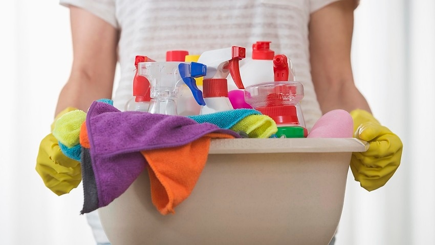Midsection of woman carrying basket of cleaning supplies