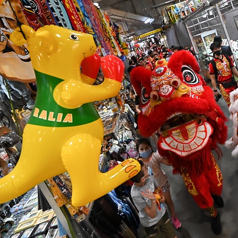 An Australian souvenir hangs as performers participate in a lion and tiger dance as part of Lunar New Year celebrations at Paddy’s Markets in Chinatown, Sydney, Saturday, January 29, 2022. (AAP Image/Steven Saphore) NO ARCHIVING