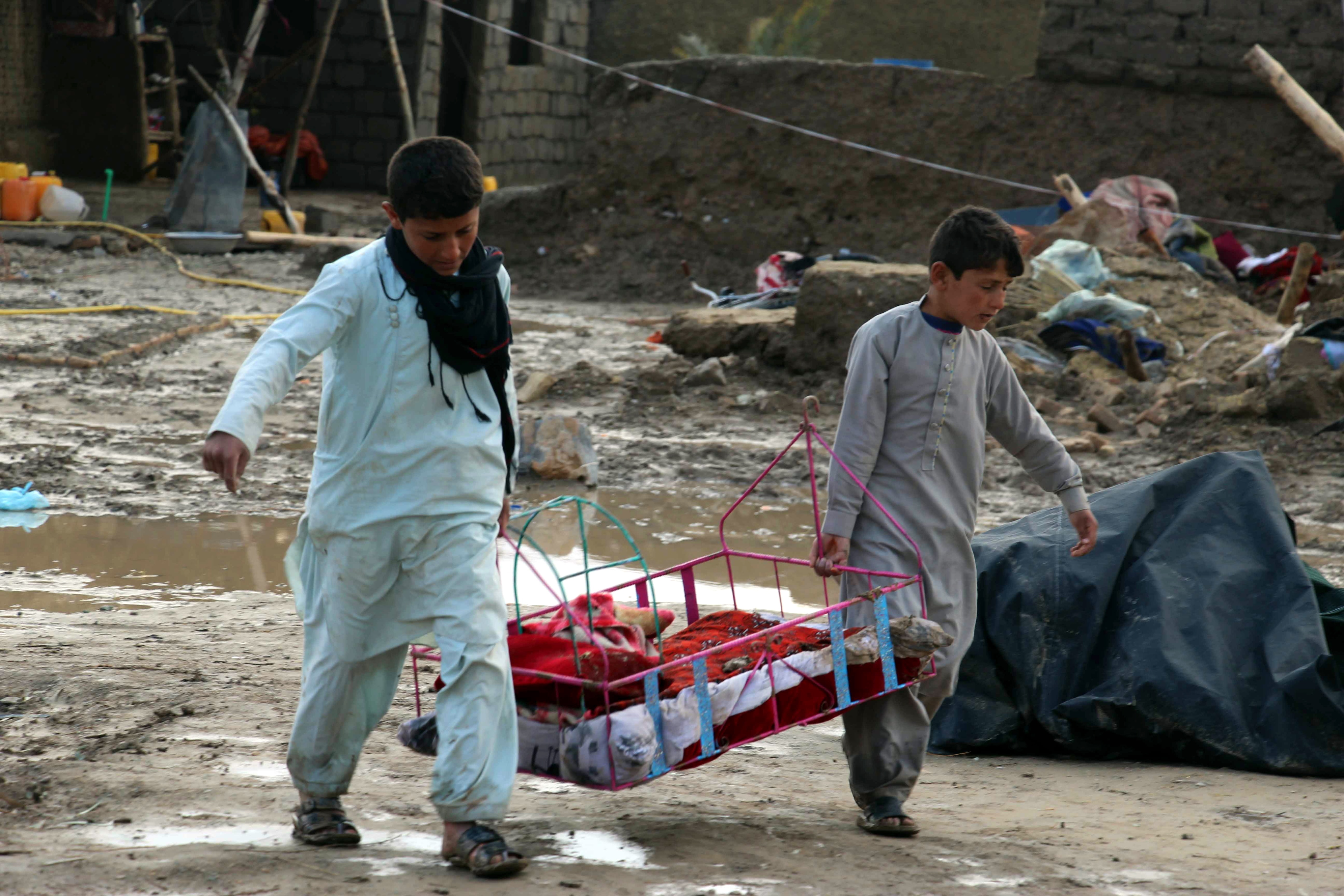 People salvage their belongings after flash floods in Kandahar, Afghanistan.
