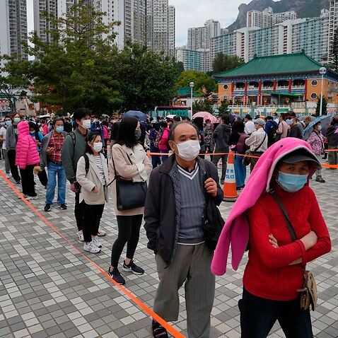 Residents line up to get tested for the coronavirus in Hong Kong, Jan. 23, 2022, after new covid cases founded in a typical densely-packed housing estate.