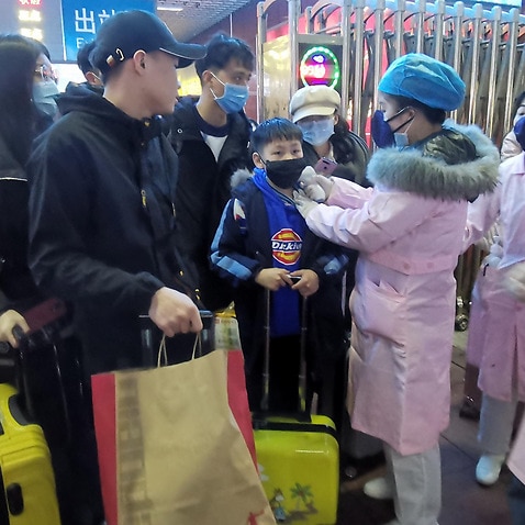 Medical staff check the body temperature of passengers as they arrive at a railway station in Yingtan City, Jiangxi province, China, 22 January 2020.