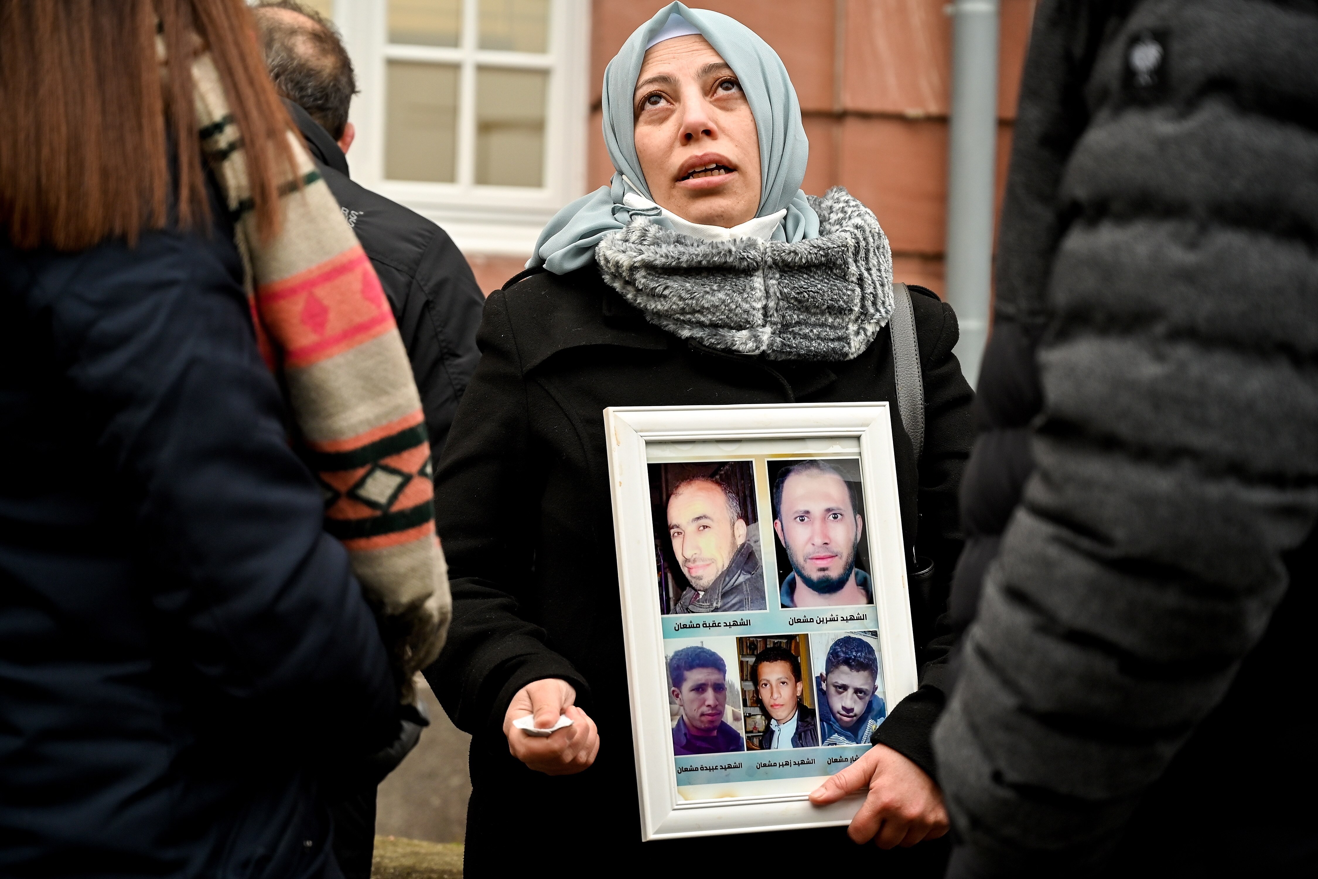 Yasmen Almashan at the Higher Regional Court in Koblenz, Germany, shows a picture of her brothers, who were killed in Syria. Photo: 13 January, 2022.