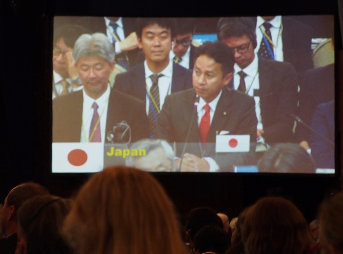 Masaaki Taniai (R), senior Japanese vice minister of agriculture, forestry and fisheries, is seen on a screen showing the plenary session Masaaki Taniai (R), senior Japanese vice minister of agriculture, forestry and fisheries, is seen on a screen showing the plenary session