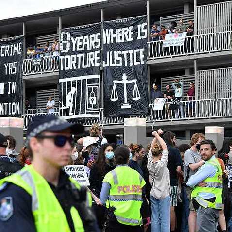 Police and protesters are seen during a rally in support of asylum seekers detained at the Kangaroo Point Central Hotel in Brisbane, Saturday, August 15, 2020.