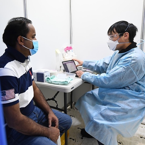 Rayees Mohammed (left) speaks with healthcare worker Chee Kin Lee prior to receiving his Covid19 vaccination at a pop-up Covid-19 vaccination clinic at the Australian Islamic Centre in Newport, Melbourne, Friday, September 10, 2021. (AAP Image/James Ross)