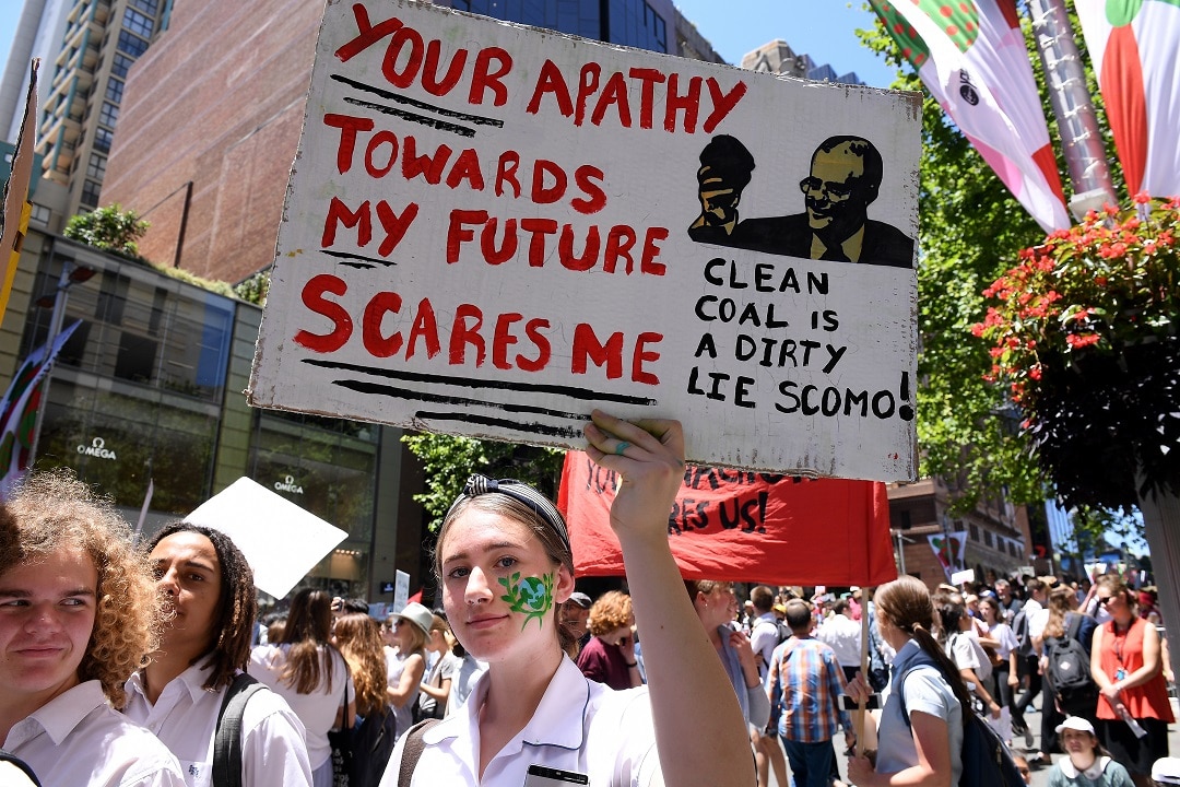 Saskia Cook-Knowles of Port Kembla High School holds a placard as thousands of students rally demanding action on climate change, in Sydney, Friday, November 30