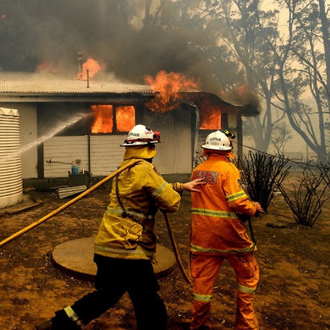 Firefighters battle the Morton Fire as it burns a home near Bundanoon, New South Wales, Australia, on Thursday, Jan. 23, 2020. 
