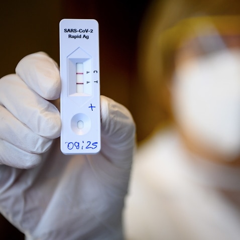 A health worker shows a positive SARS-CoV-2 Rapid Antigen Test