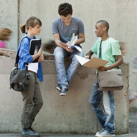 Friends discussing homework together (Getty Images/PhotoAlto/Odilon Dimier)