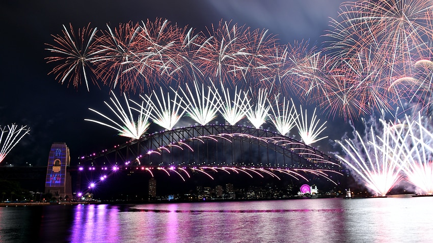 The midnight fireworks light up Sydney Harbour and the Sydney Harbour Bridge.