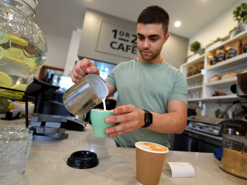 A barista is seen prepairing a coffee at a cafe in Canberra