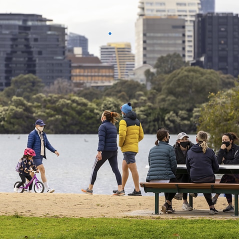 People are seen exercising and socialising at Albert Park Lake in Melbourne, 19 September 2021.