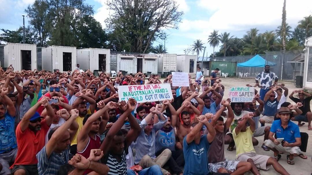 Refugees protest on Manus Island with Australian Senator Nick McKim (light blue shirt, centre) during his visit in 2017. 
