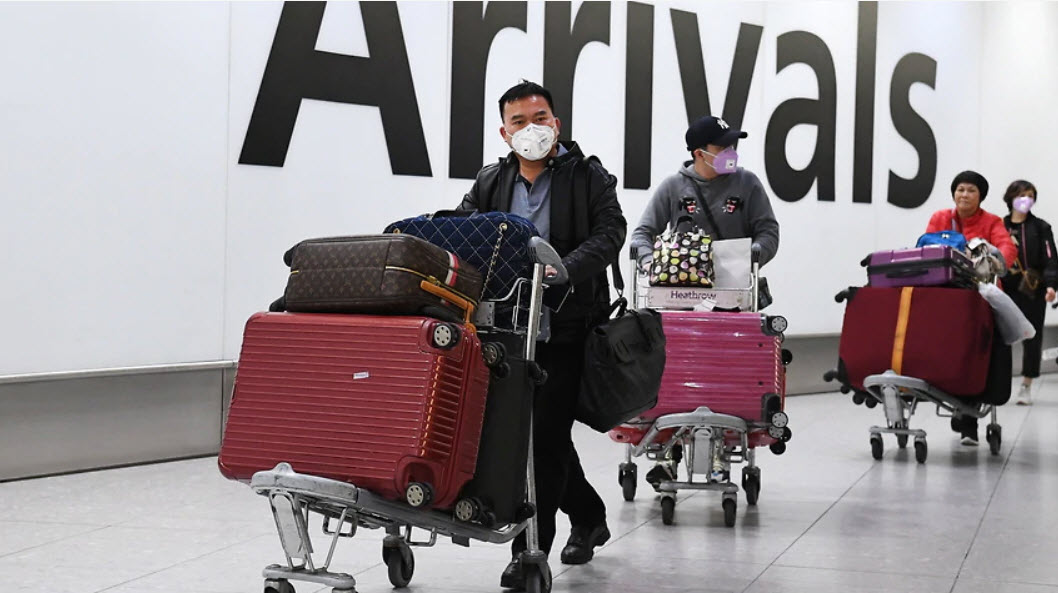 Passengers arriving at airport wearing masks