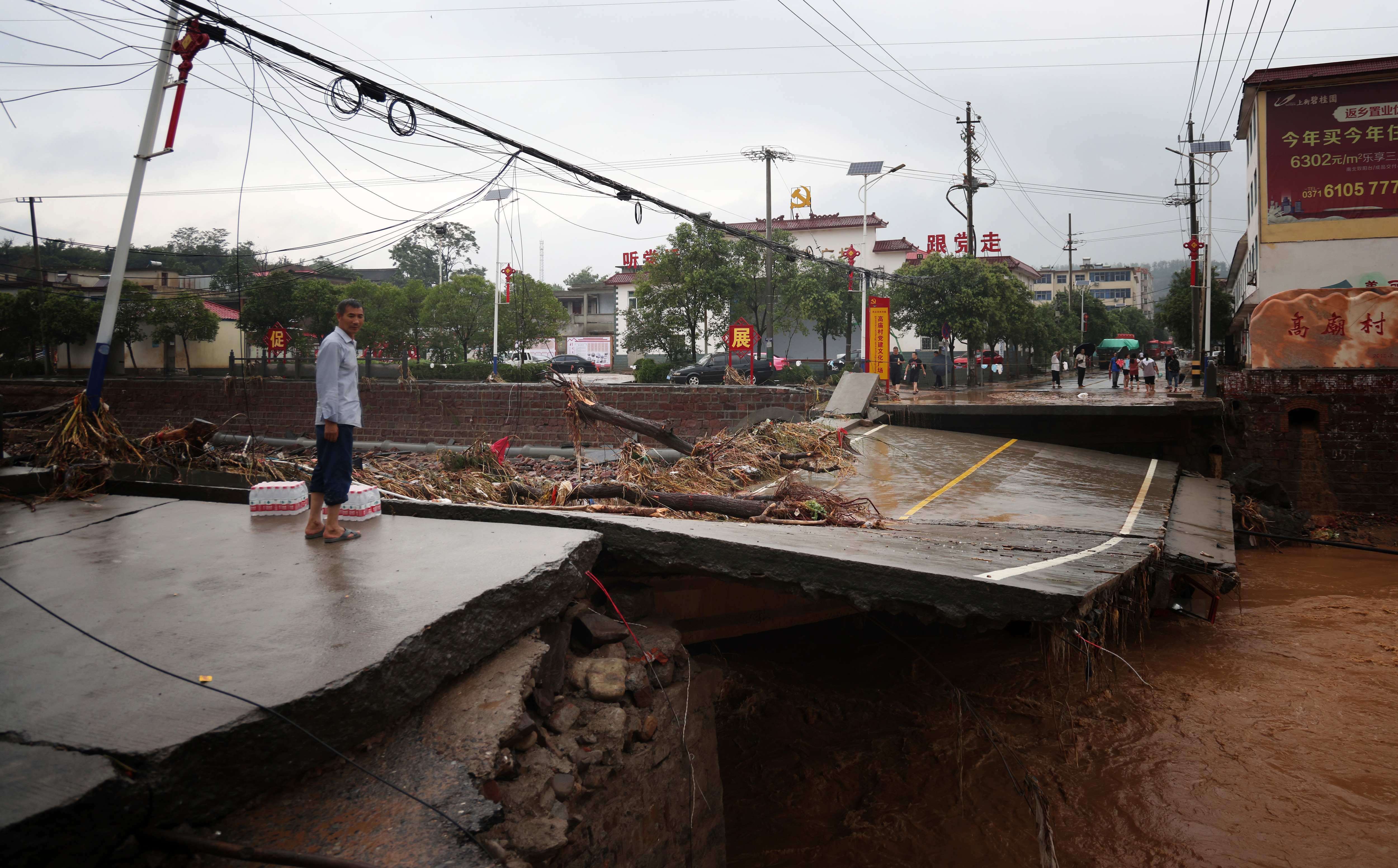 Damaged cars, bridges and roads are seen after a torrential rainfall in Gongyi City in central China's Henan Province, on 21 July, 2021.  