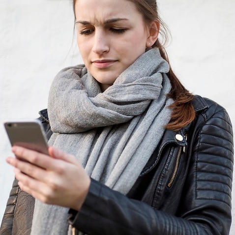 یک زن در حال استفاده از گوشی تلفن همراه خود
