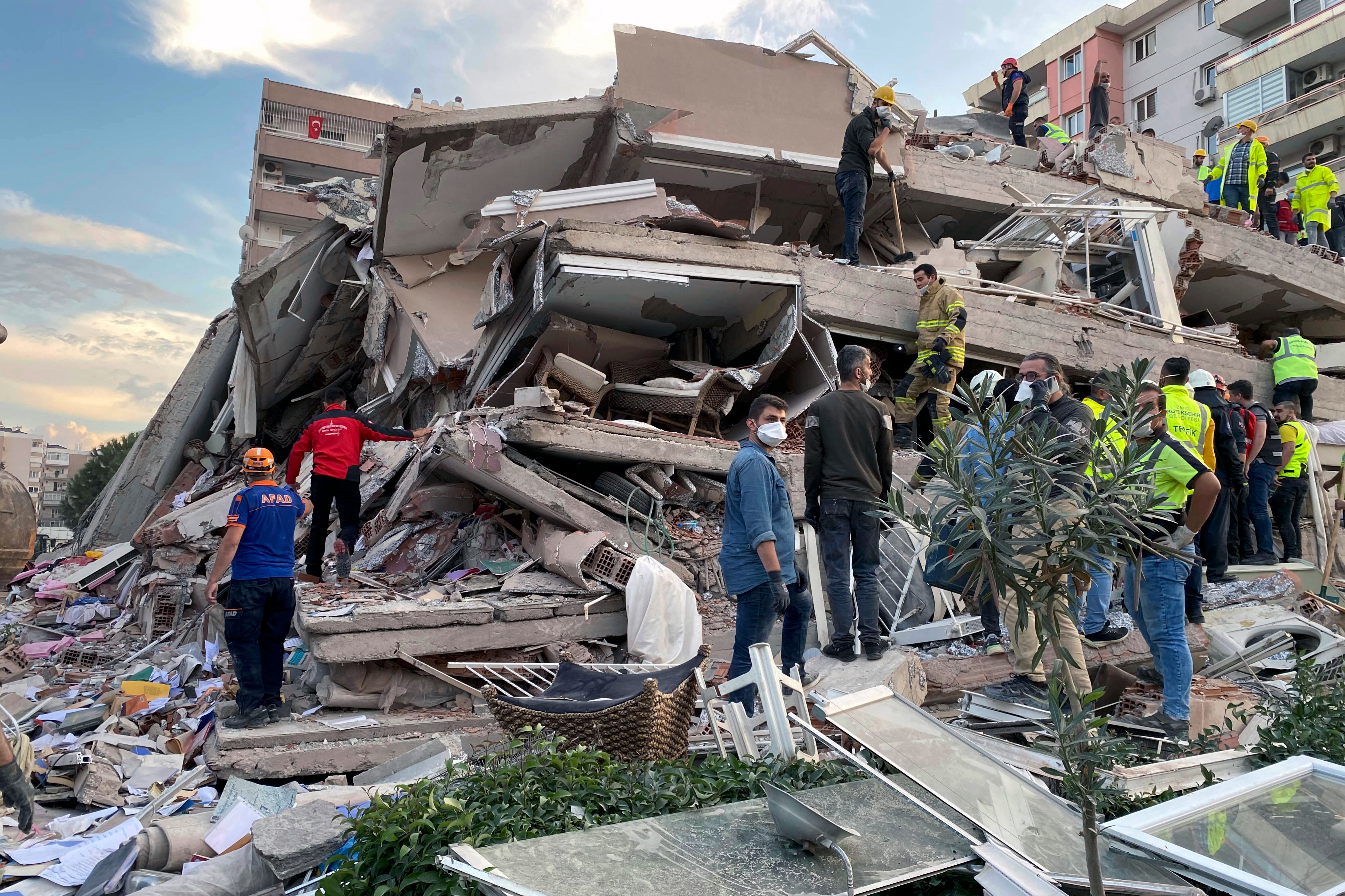 Rescue workers try to save people trapped in the debris of a collapsed building, in Izmir, Turkey, Friday, Oct. 30, 2020