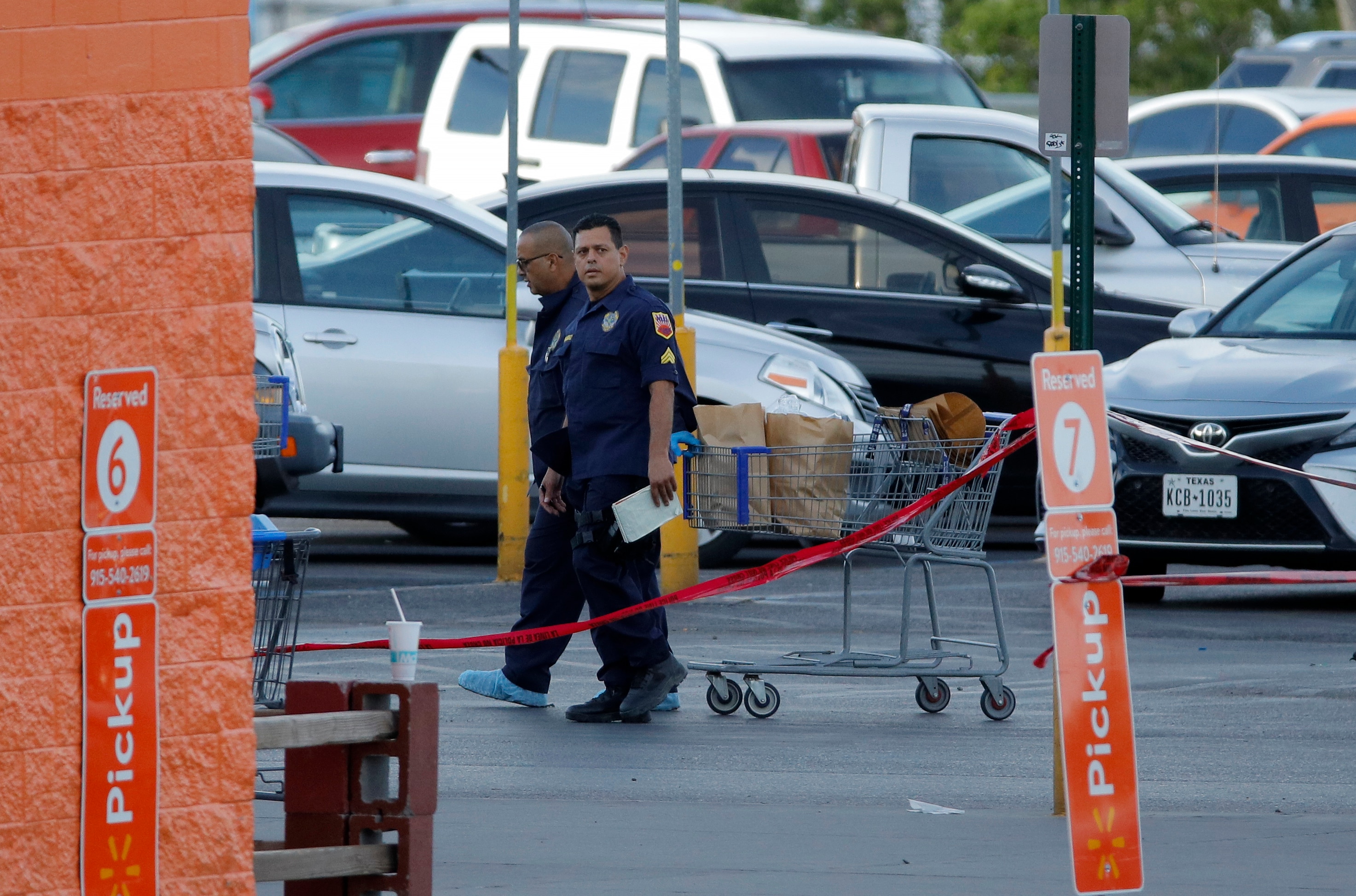 Police officers pull a shopping cart at the scene of the shooting. 