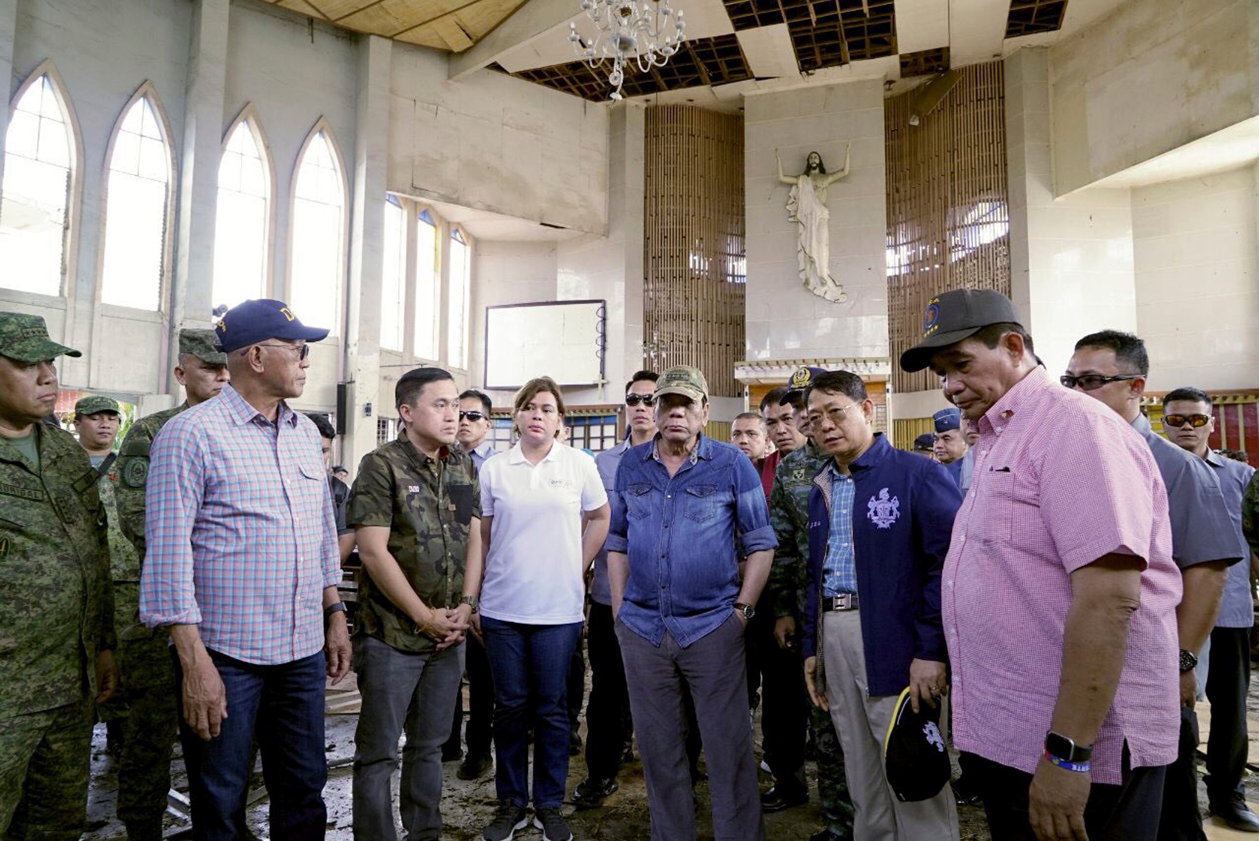 Philippine President Rodrigo Duterte, center, inspects a Roman Catholic Cathedral a day after two bombs exploded during a Sunday Mass, in Jolo, in the southern Philippines.