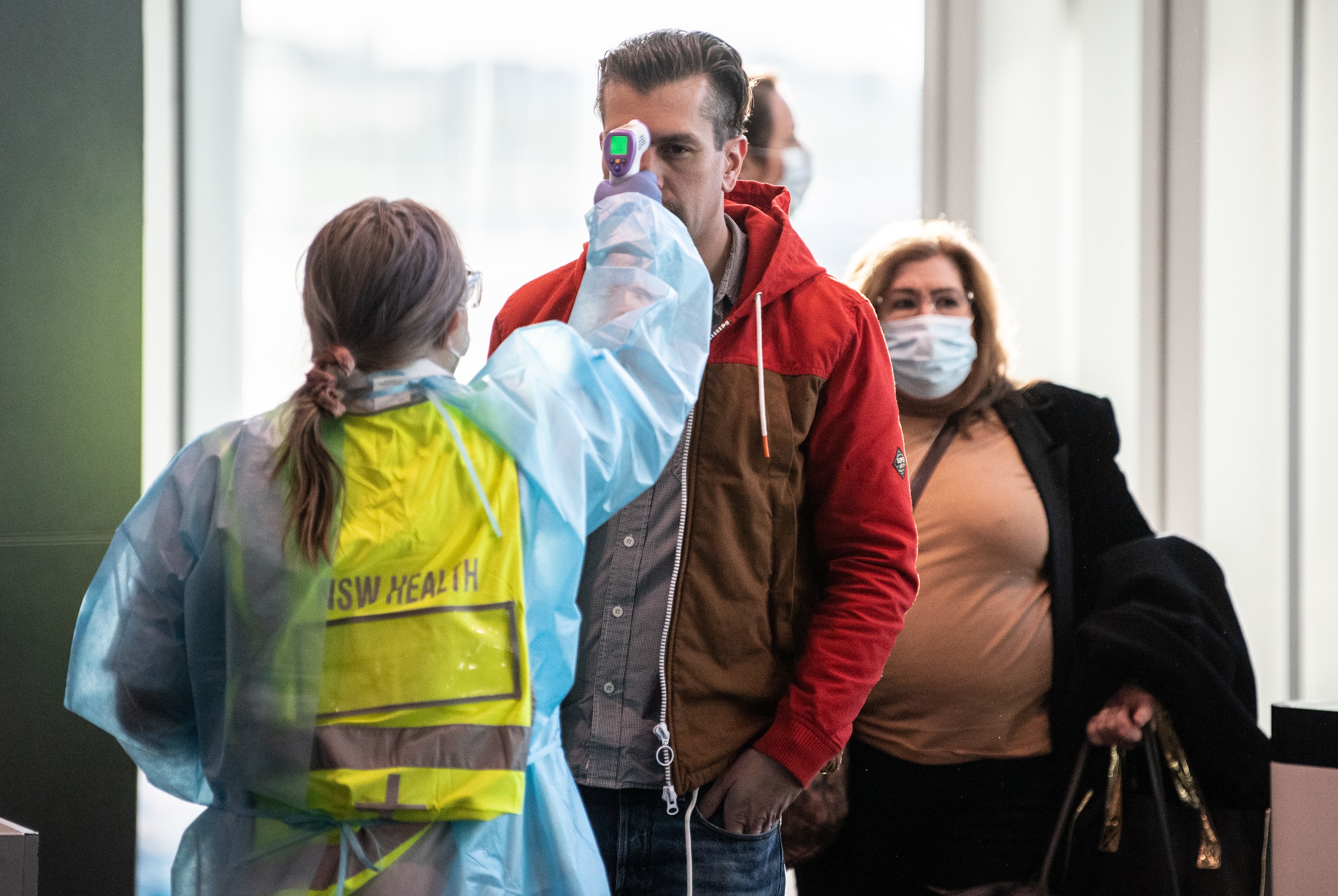 Passengers arriving from Melbourne are screened by health workers in Sydney. 