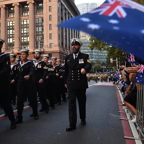 People watch on as the ANZAC day parade makes its way through Sydney.