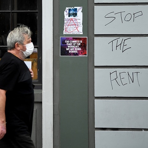 A man walks past a sign saying Stop the Rent on King Street in Newtown in Sydney, 23 March 2020. 