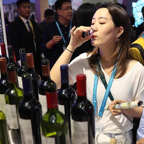 People taste wine at the China International Import Expo in 2019. 