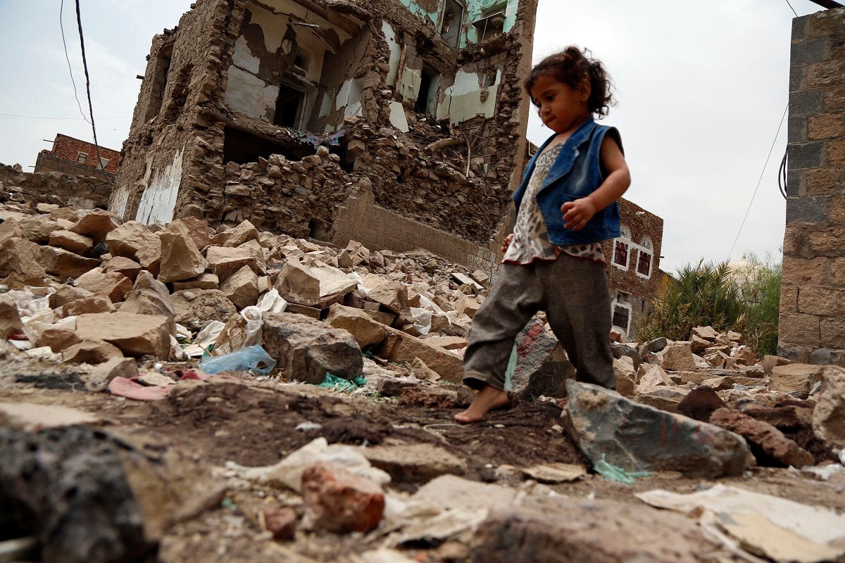 A Yemeni girl walks on rubble of a building destroyed in an airstrike carried out by the Saudi-led coalition, at the Old City of Sana'a.