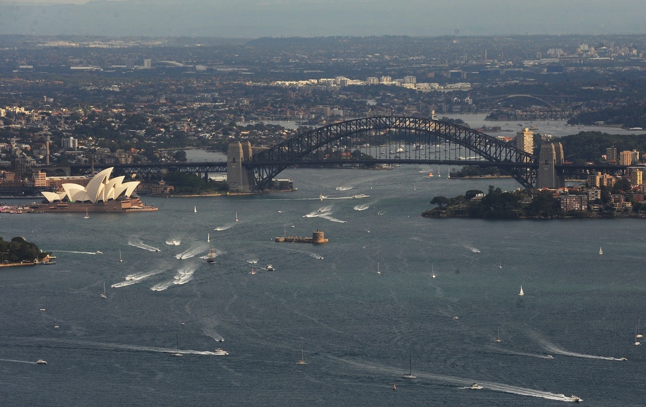 An aerial view of the Sydney Harbour Bridge and the Sydney Opera House.