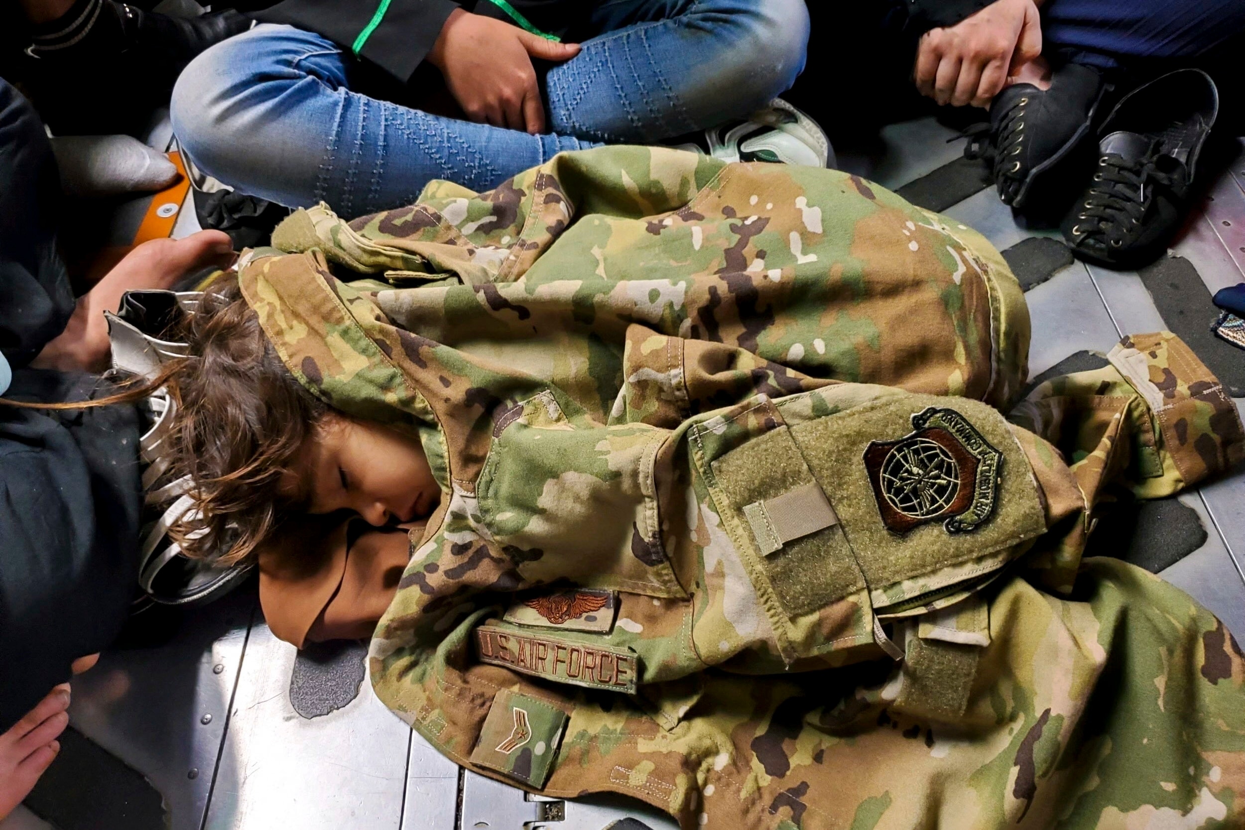 An Afghan child sleeps on the cargo floor of a United States Air Force C-17 Globemaster III.