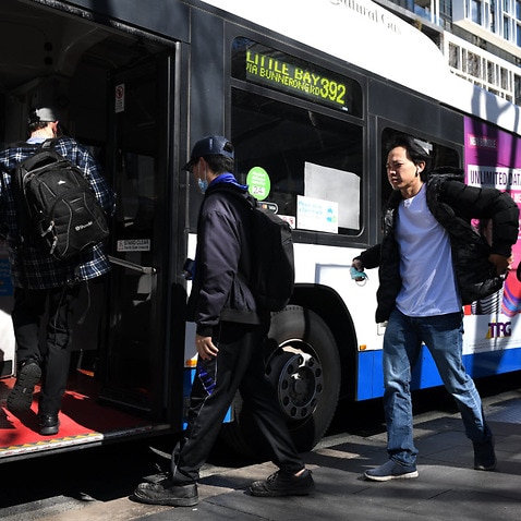 Commuters are seen boarding a bus in Sydney, Tuesday, 18 August, 2020. 