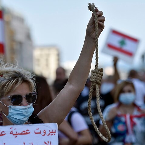 An anti-government protester carries a mock gallows rope symbolizing the execution of Lebanese politicians during a protest in Beirut
