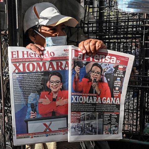 A vendor shows the covers of newspapers depicting left-wing opposition candidate Xiomara Castro, in Tegucigalpa on November 29, 2021.