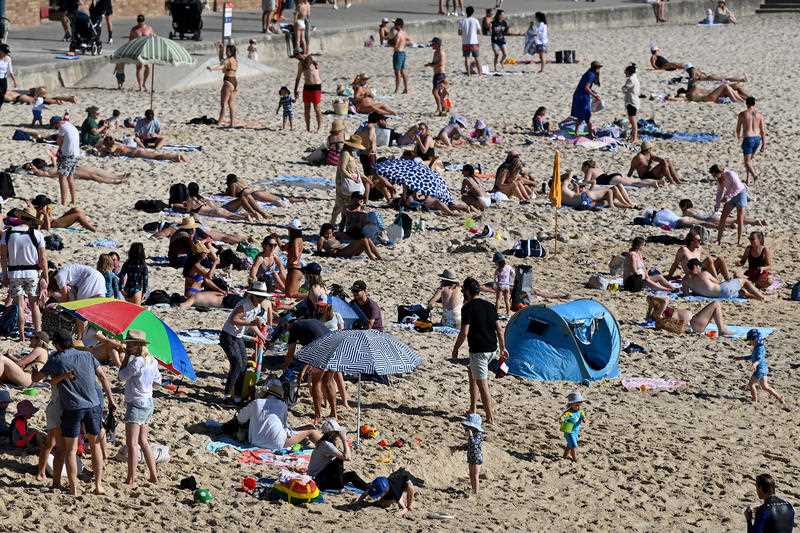 Crowds of people sit on the sand at Bronte Beach in Sydney.