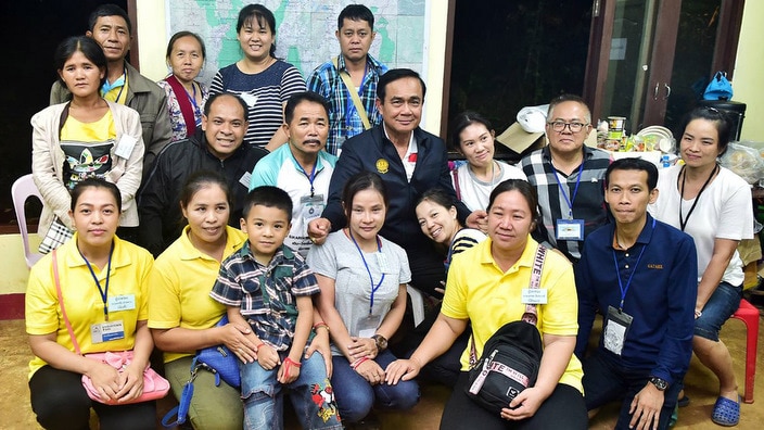 Thai Prime Minister Prayut Chan-o-cha with family members of a group of football players and their coach who had been trapped in a cave.