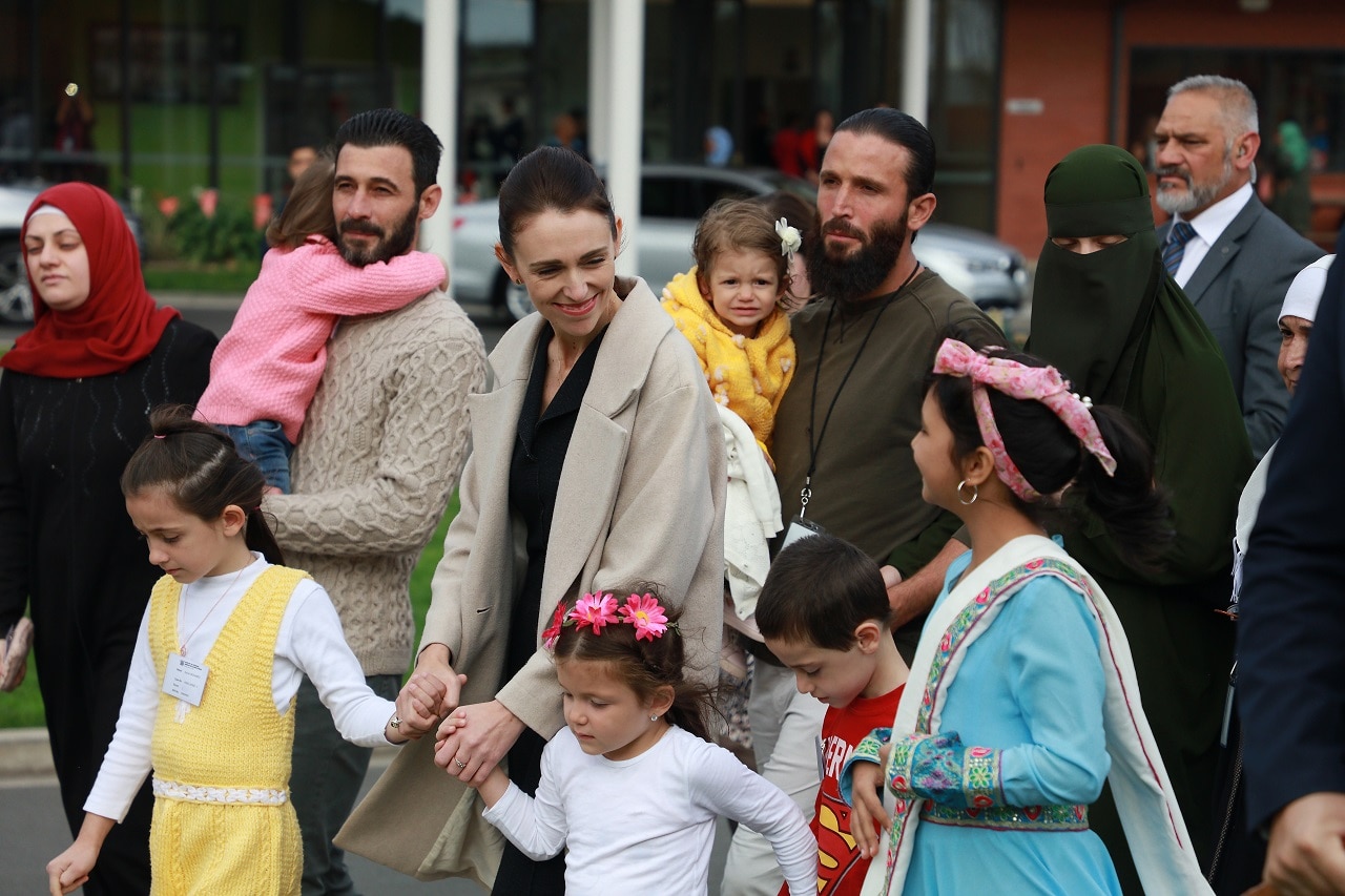 Jacinda Ardern walks to plant a tree of remembrance with people connected to the Christchurch terror attacks.