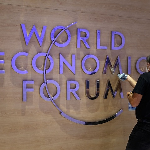 A worker cleans a sign of the logo of the World Economic Forum (WEF) inside the Congress centre ahead of the WEF annual meeting in Davos on May 22, 2022. (Photo by Fabrice COFFRINI / AFP) (Photo by FABRICE COFFRINI/AFP via Getty Images)