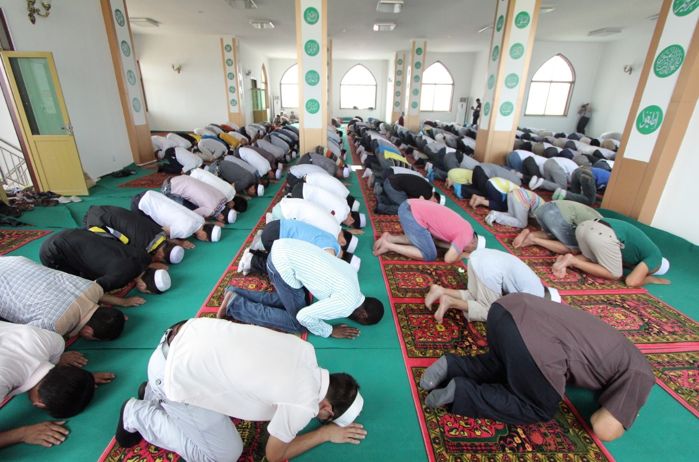 An African Muslim, center, kneels and bows among Chinese Muslims as they attend an Eid al-Fitr morning prayer An African Muslim, center, kneels and bows among Chinese Muslims as they attend an Eid al-Fitr morning prayer
