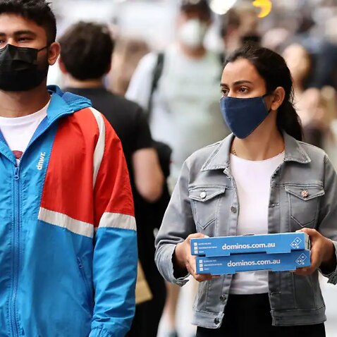 People wearing face masks are seen walking in Melbourne.