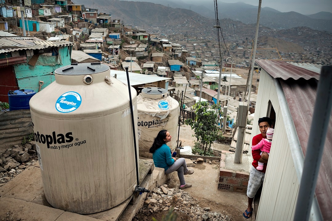 Residents of the Asientamento Humano 'Nadin Heredia' get their water tanks filled weekly.