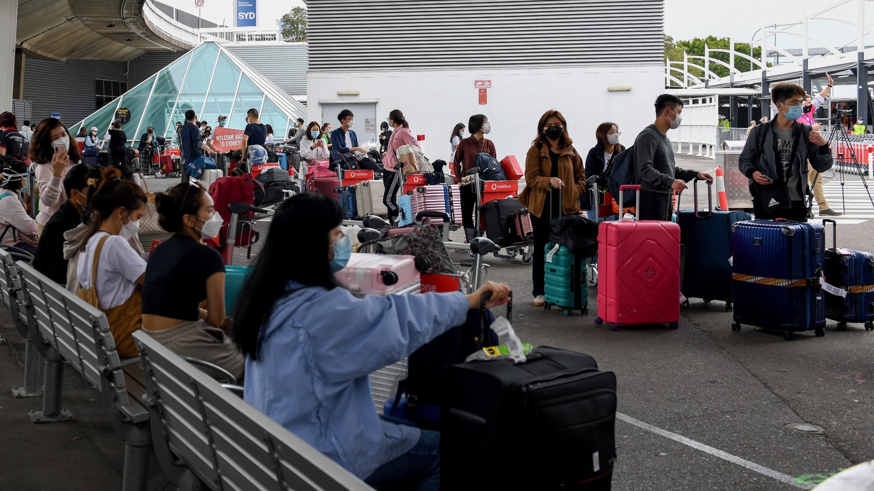 International students line up for coaches after arriving at Sydney Airport in Sydney, Monday, December 6, 2021. AAP/Bianca De Marchi