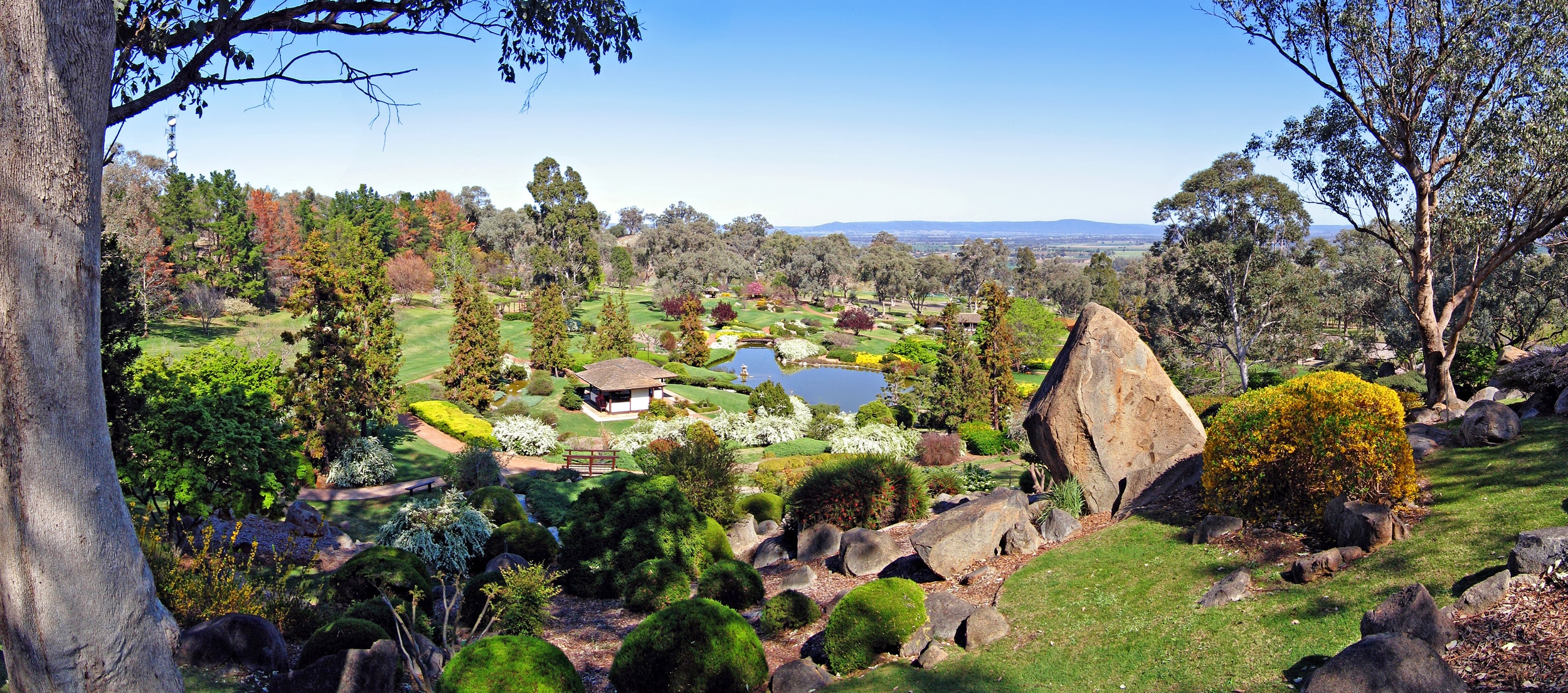 Panoramic view from Cowra Mountain at the Cowra Japanese Garden. The view takes in the gardens and the plains of the Cowra Shire across to the nearby mountains.