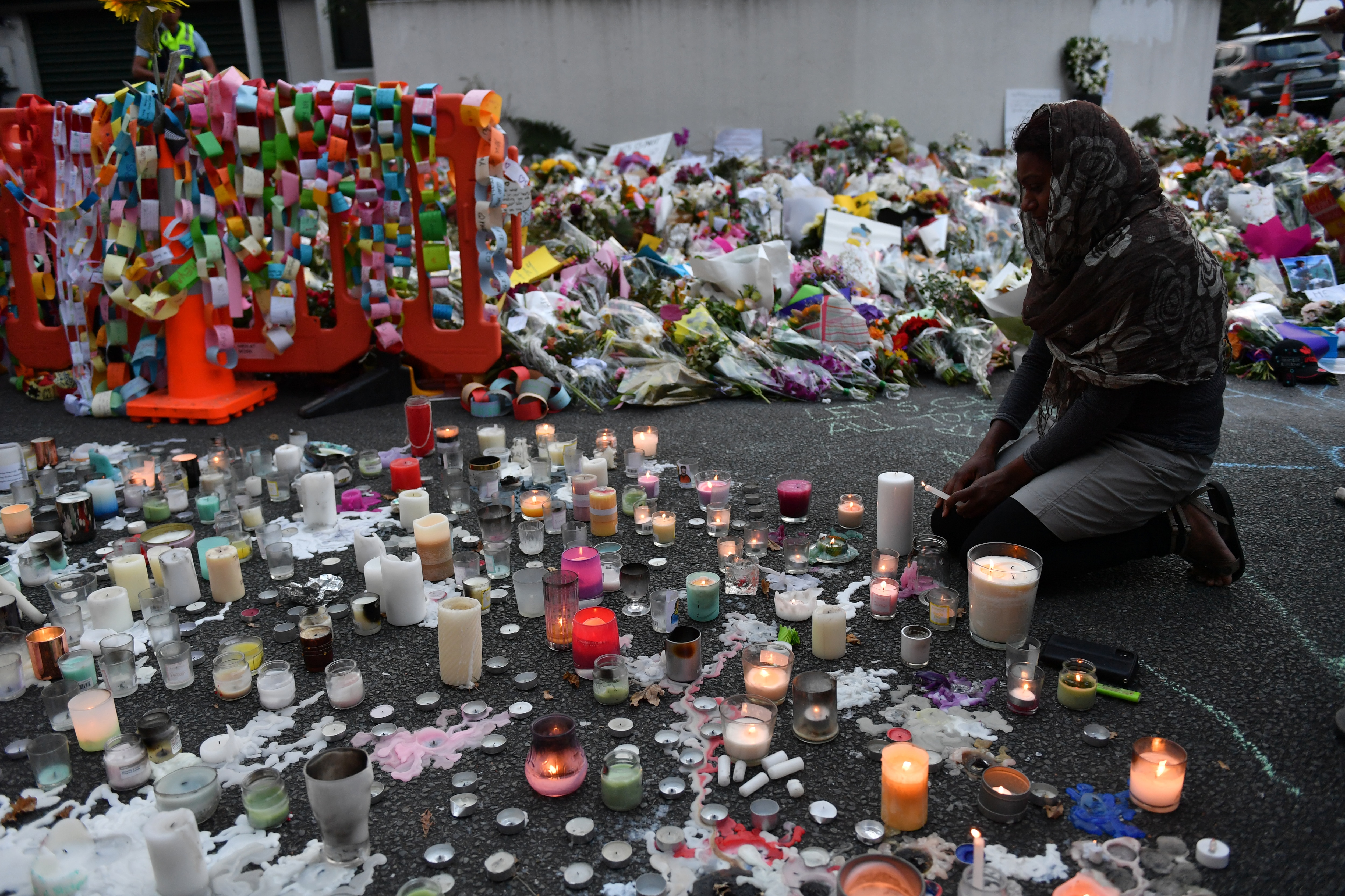 A Muslim worshipper lights candles at a makeshift memorial at the Al Noor Mosque in Christchurch. A Muslim worshipper lights candles at a makeshift memorial at the Al Noor Mosque in Christchurch.