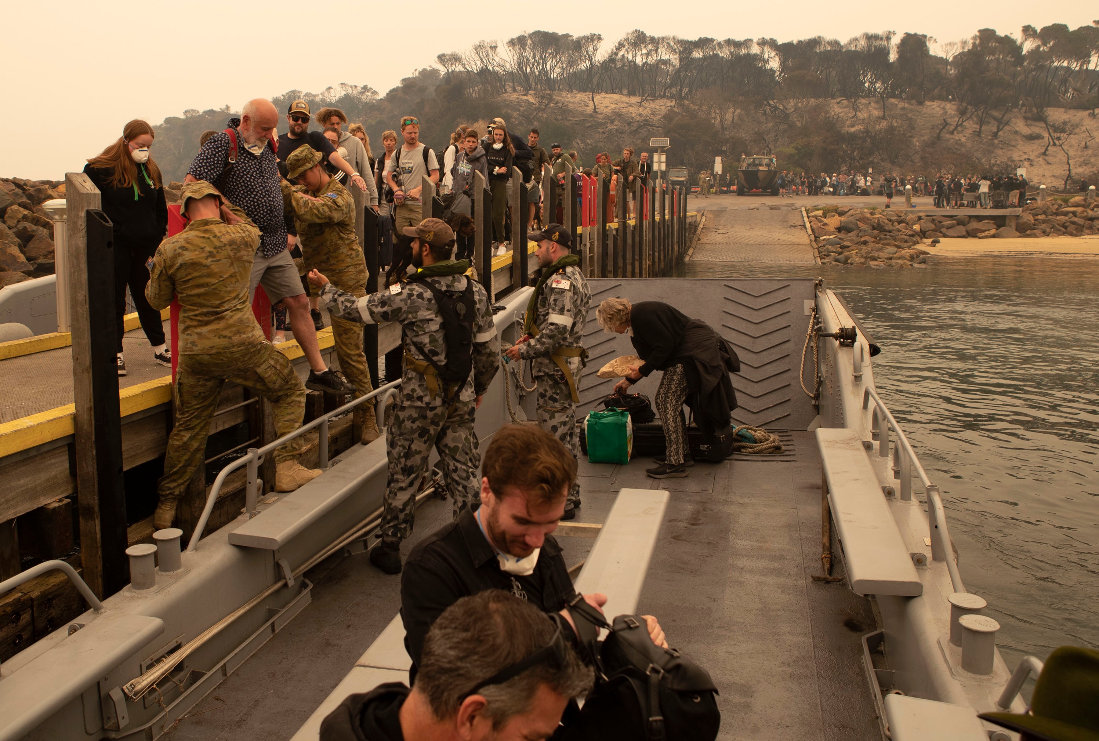 Bushfire evacuees boarding one of HMAS Choules' landing craft at Mallacoota before being ferried to the ship on January 3, 2020.
