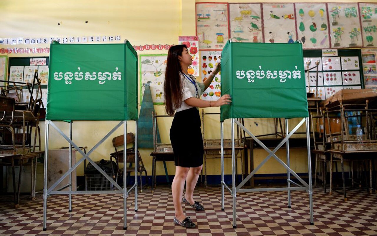 A member of the Cambodian National Election Committee (NEC) prepares a voting booth at a polling station in Phnom Penh on July 28, 2018.