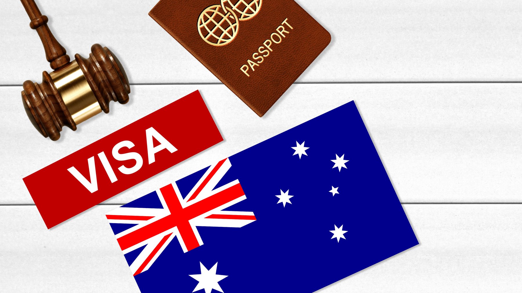 Visa to Australia concept with VISA text near passport cover and Australian flag, hammer on white wooden background from above with copy space